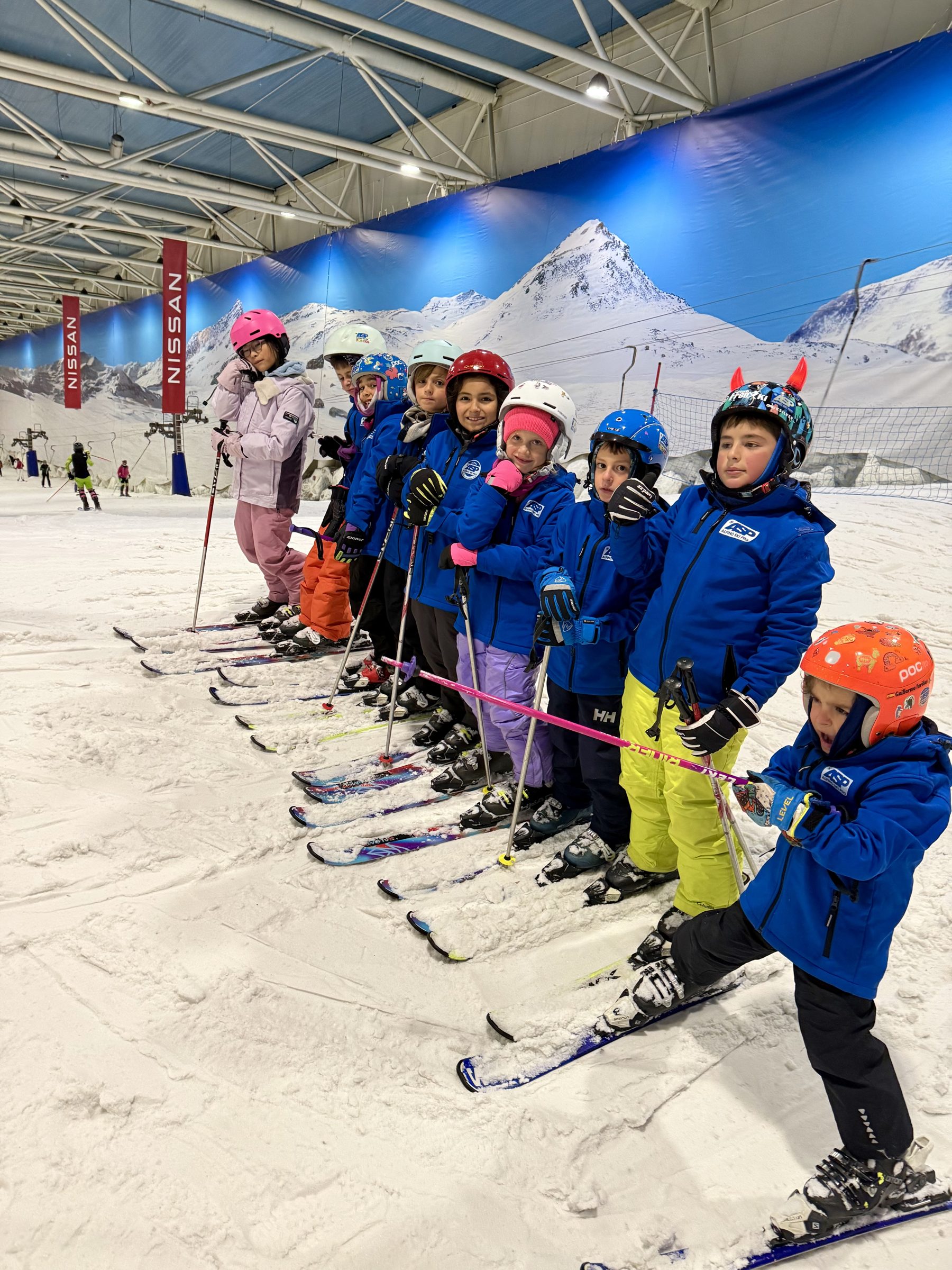 Grupo de niños y equipo de Alpino Ski Pro en una pista de nieve